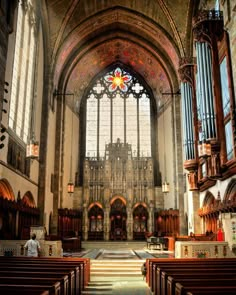 the inside of a church with pews and stained glass windows