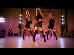 three women are dancing on the dance floor with their arms in the air and one woman is wearing black