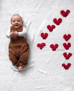 a baby is laying on a blanket with hearts