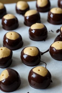 chocolate covered desserts sitting on top of a baking sheet