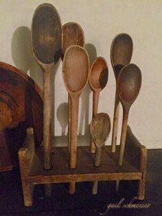 old wooden spoons are lined up on a shelf