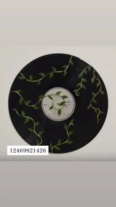 a black record with green leaves on it