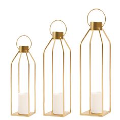 three gold metal lanterns with white candles inside one is empty and the other has a candle in it