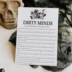 a dirty minds card sitting on top of a table next to a skull and mesh net