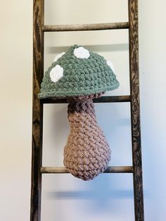 a crocheted mushroom sitting on top of a ladder