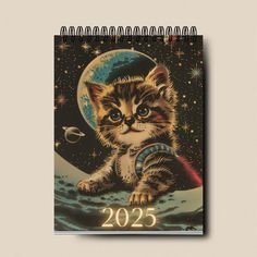 a calendar with a kitten sitting on the moon