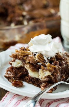 a piece of cake sitting on top of a white plate next to a glass of milk