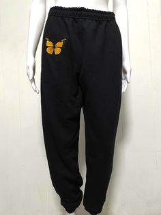 A beautiful black and orange monarch butterfly embroidered onto some comfy sweatpants. Wear it as pajamas, for running, dancing, skating, and more!  SPECS: -Embroidered -Fruit of the loom Sweatpants (Light to Mid weight 8oz) -60% Cotton, 40% Polyester -Design is 3.9x3.5in -Quick and Quality Production! Designed by me! Cece :) Instagram.com/cecespatchedprints ----- Turnaround time could range from 2-14 days depending on complexity and communication. (Simple text embroidery turnaround times are usually very quick) Please reach out with any questions I'm happy to answer :) Other apparel and brand options + more complex custom embroidery are available on https://cecespatchedprints.etsy.com! ----- CANCELLATION policy:  If the product is shipped - there will be no option for cancellation. Please Butterfly Pants, Comfort Gifts, Comfy Sweatpants, Sweat Joggers, Monarch Butterfly, Fruit Of The Loom, Custom Embroidery, Jogging, Pajamas