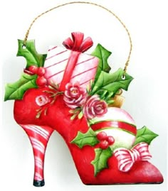 a christmas shoe ornament with holly and bells hanging from it's side