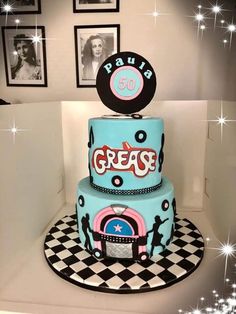 a three tiered cake with the word grease on it and an image of a woman's face