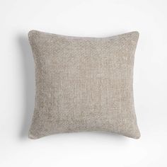 a beige pillow on a white wall