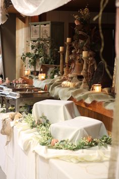 the table is covered with white cloths and flowers, candles are on top of it