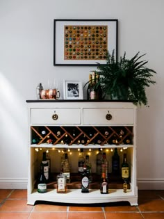 a white cabinet with bottles and lights on it