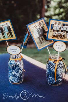 two mason jars with pictures on them sitting on top of a blue table cloth covered table