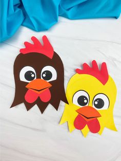 two paper chickens on a bed with blue sheets