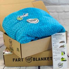 a blue blanket sitting inside of a cardboard box