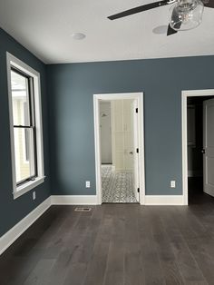 an empty room with hard wood floors and blue walls is pictured in this image from the front door