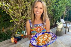 a woman holding a plate with food on it