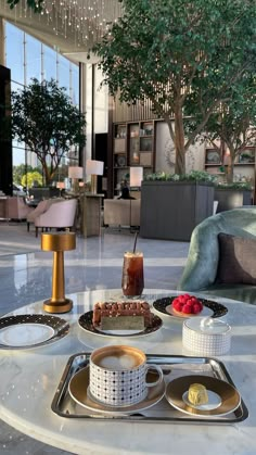 a table topped with cakes and desserts next to a couch in a living room