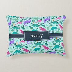 a personalized pillow with dinosaurs and plants on it, that says avery