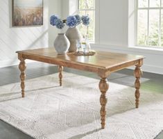 a wooden table sitting on top of a rug in a living room next to two vases