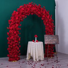 a table topped with red roses next to a wooden sign