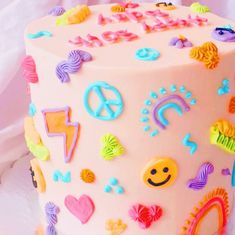 a white cake decorated with colorful decorations and peace signs