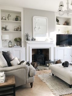 a living room filled with furniture and a flat screen tv mounted on the wall above a fire place