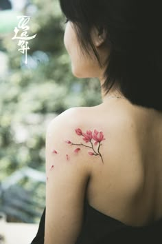 the back of a woman's shoulder with pink flowers on it