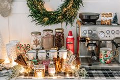 a coffee maker surrounded by christmas decorations and candles