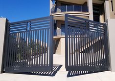 two gates open to the outside of a building with a palm tree in front of it