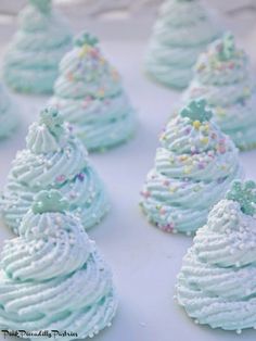 small cupcakes with frosting and sprinkles are arranged on a table