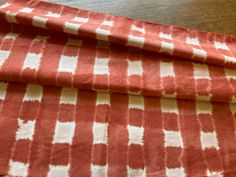 an orange and white patterned fabric sitting on top of a wooden table