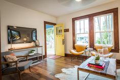 a living room filled with furniture and a flat screen tv on top of a wooden table