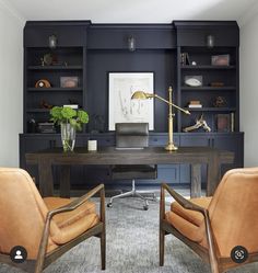 two leather chairs sitting in front of a desk