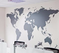 an office with desks and a world map on the wall