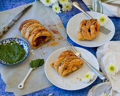 two white plates topped with pastries on top of a blue table covered in flowers