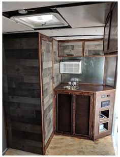 the inside of an rv with wood paneling on the walls and cabinets in it