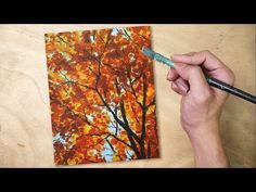 someone is painting an autumn tree with acrylic paint