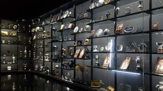 a display case filled with lots of different types of clocks and awards on glass shelves