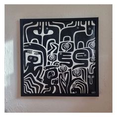 a black and white painting hanging on the wall