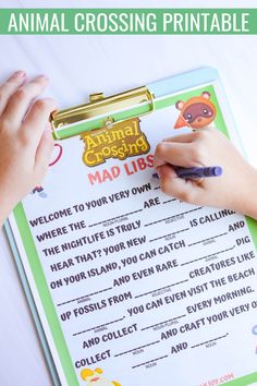 a person writing on a clipboard with the words animal crossing printable in front of it