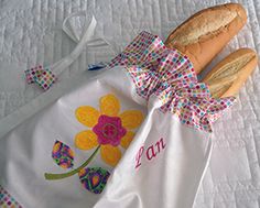 three baguettes sitting on top of a bed next to a white towel with flowers