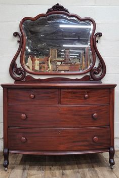 an antique dresser with a large mirror on it's top and drawers below the drawer