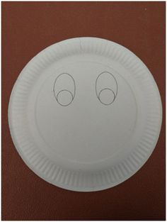 a white paper plate with two eyes drawn on the front and one eye drawn on the back