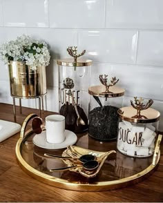 a table topped with two cups and saucers on top of a wooden table next to a wall