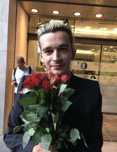 a man holding a bouquet of red roses