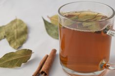 a cup of tea with cinnamon sticks and leaves