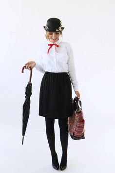 a woman wearing a hat and holding an umbrella in her hand while standing against a white background