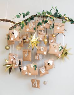 brown paper bags hanging from a tree branch with ornaments on them and gold star ornament